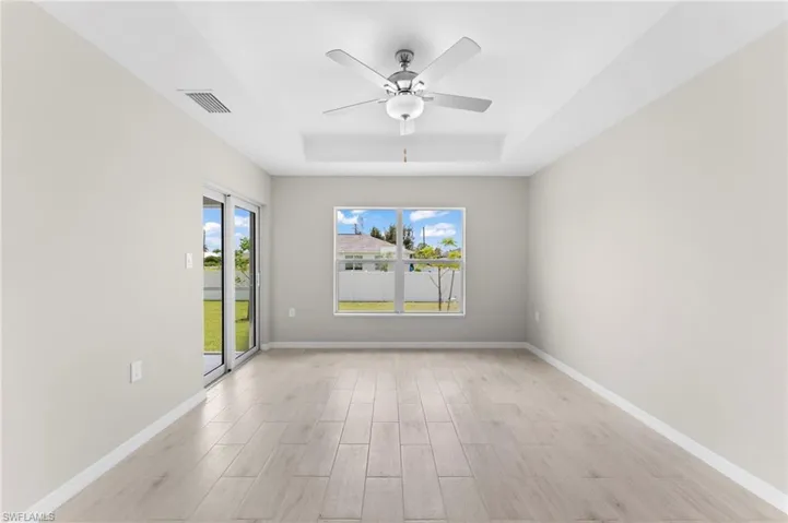 Spare room with ceiling fan and a tray ceiling