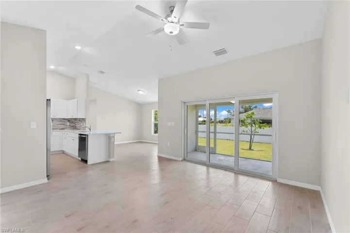 Unfurnished living room with high vaulted ceiling and ceiling fan