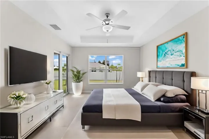 Bedroom featuring ceiling fan and a tray ceiling