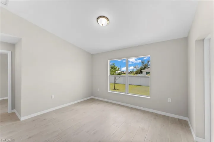 Spare room with vaulted ceiling and light hardwood / wood-style flooring