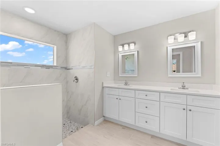 Bathroom with a tile shower and double sink vanity