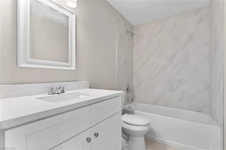 Full bathroom featuring vanity, tiled shower / bath, and toilet