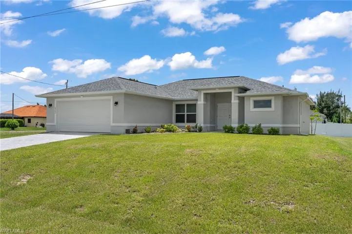 View of front of property with a garage and a front yard