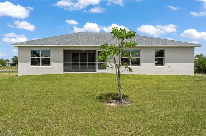 Back of property with a lawn