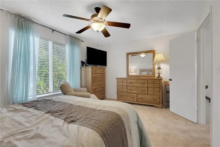 Bedroom featuring carpet floors, a ceiling fan, and a textured ceiling