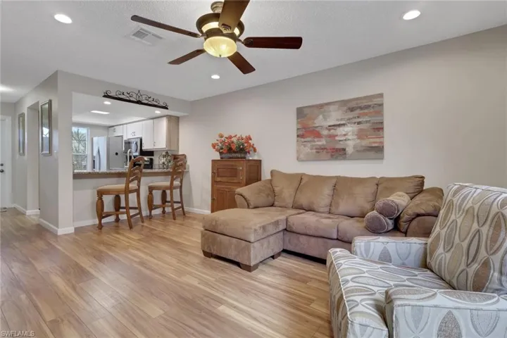 Living room featuring light wood finished floors, recessed lighting, a ceiling fan, and a textured ceiling