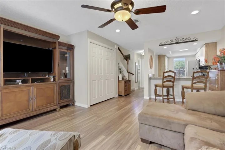 Living area with a ceiling fan, light wood-style floors, recessed lighting, and a textured ceiling