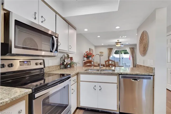 Kitchen featuring stainless steel appliances, white cabinetry, light wood-style floors, recessed lighting, and ceiling fan