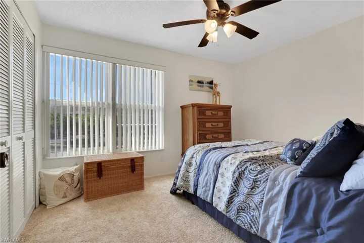 Carpeted bedroom featuring a ceiling fan and a textured ceiling