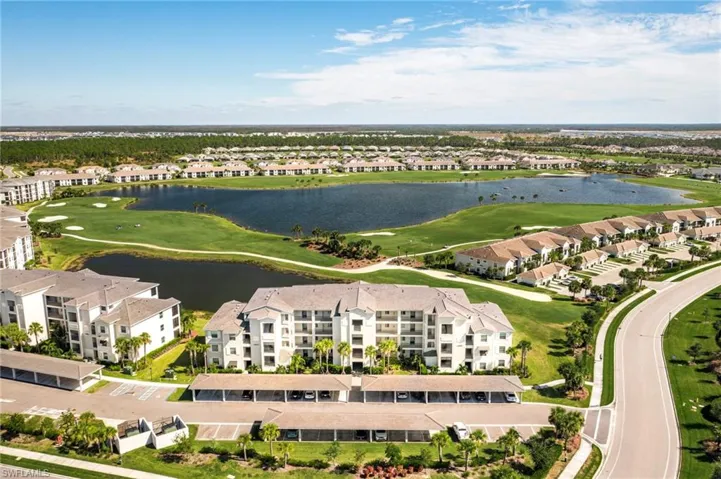 Aerial view of residential area featuring a golf club and a nearby body of water