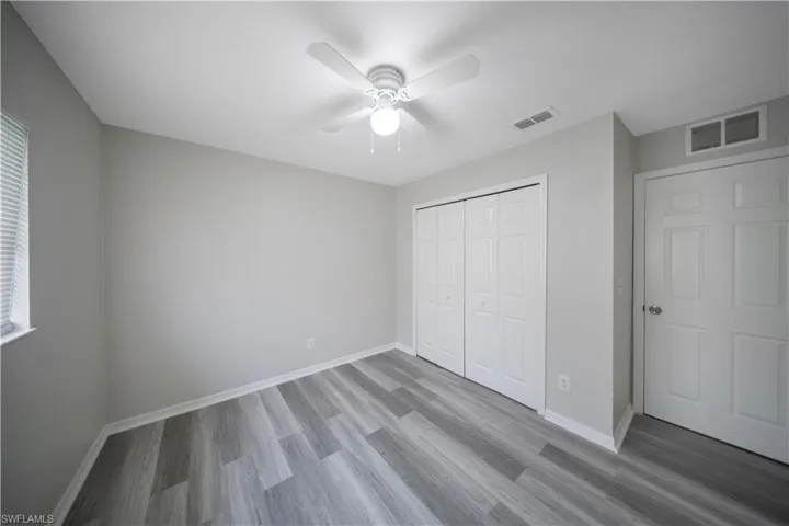 Unfurnished bedroom featuring wood finished floors, a closet, and ceiling fan
