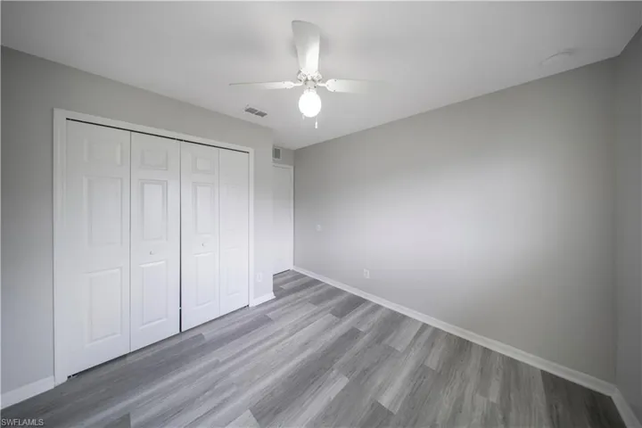 Unfurnished bedroom with wood finished floors, a ceiling fan, and a closet