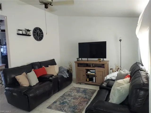 Living room featuring ceiling fan and light tile flooring