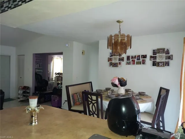Dining area featuring a notable chandelier, concrete floors, and vaulted ceiling