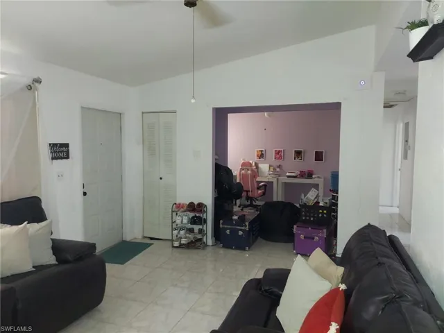 Tiled living room featuring vaulted ceiling