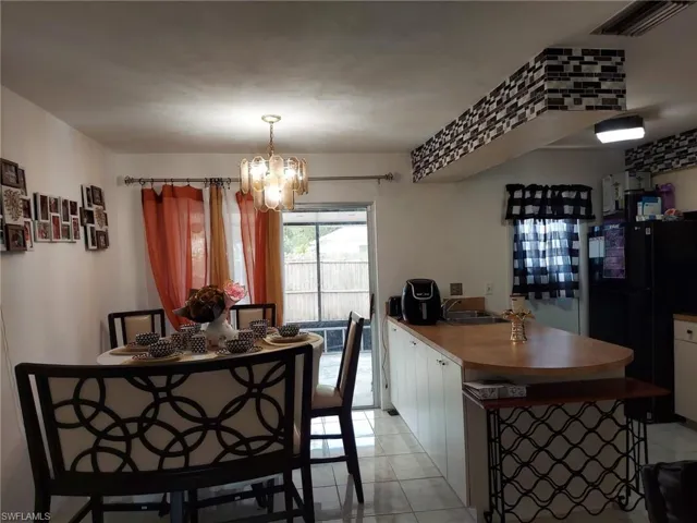 Dining space with an inviting chandelier and light tile floors