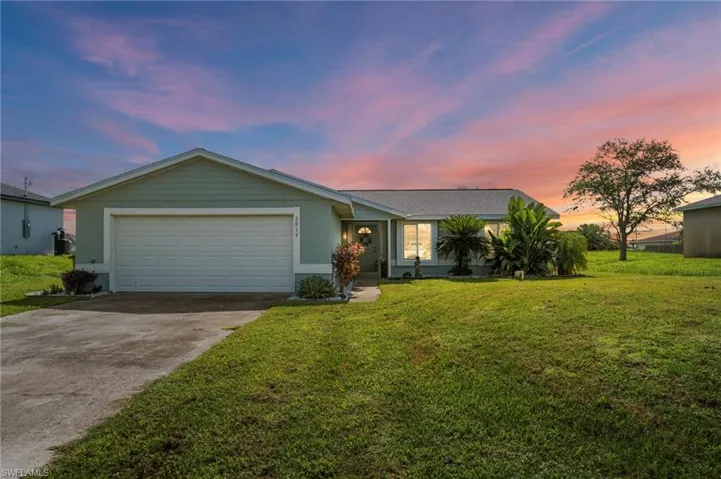 Single story home with concrete driveway, a garage, and a front yard