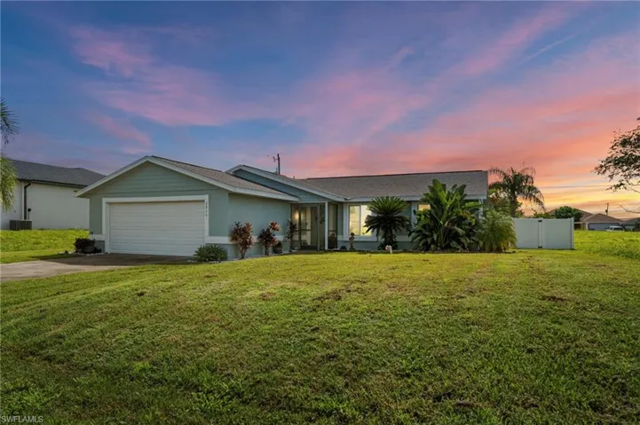 View of front of home with a garage and driveway