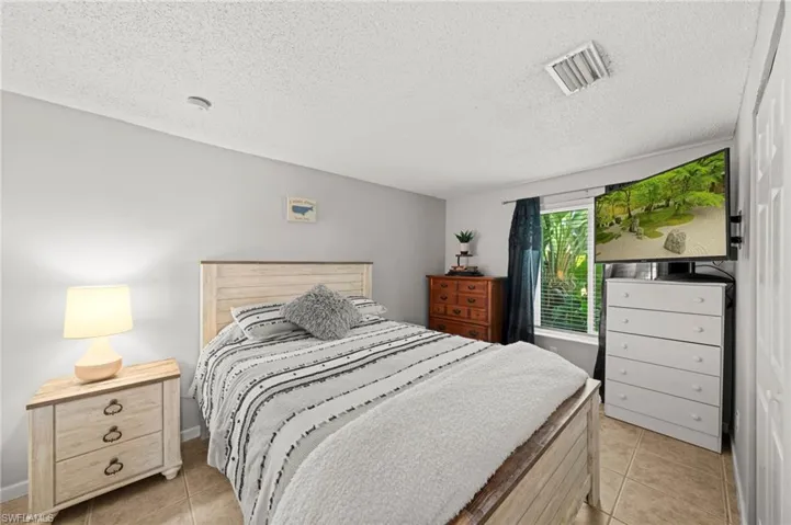 Bedroom with light tile patterned floors and a textured ceiling
