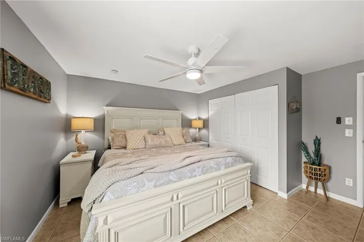 Bedroom featuring light tile patterned flooring, a closet, and ceiling fan