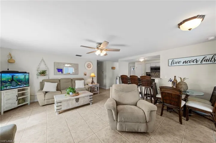 Living room with light tile patterned floors and a ceiling fan