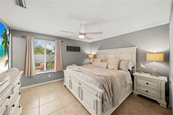 Bedroom with light tile patterned flooring and ceiling fan