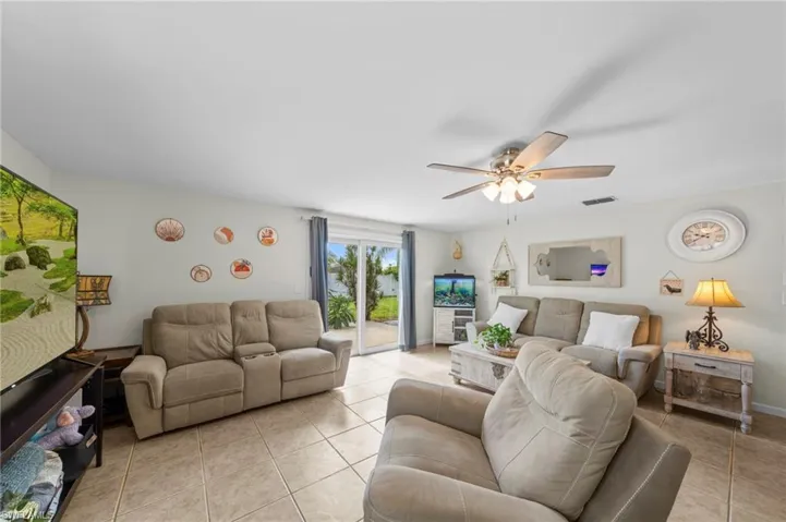 Living area featuring light tile patterned flooring and a ceiling fan