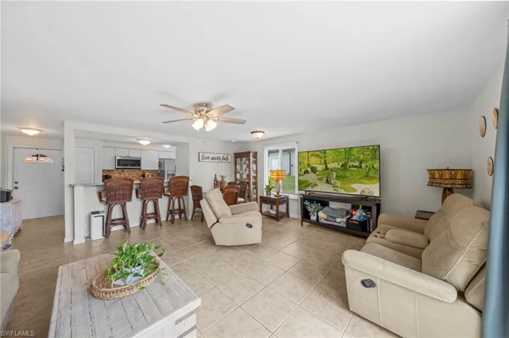Living room with ceiling fan and light tile patterned floors