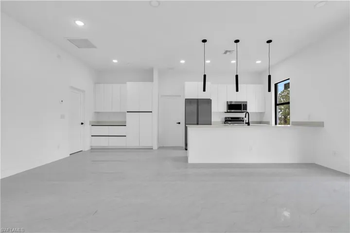 Kitchen featuring appliances with stainless steel finishes, modern cabinets, white cabinets, and recessed lighting