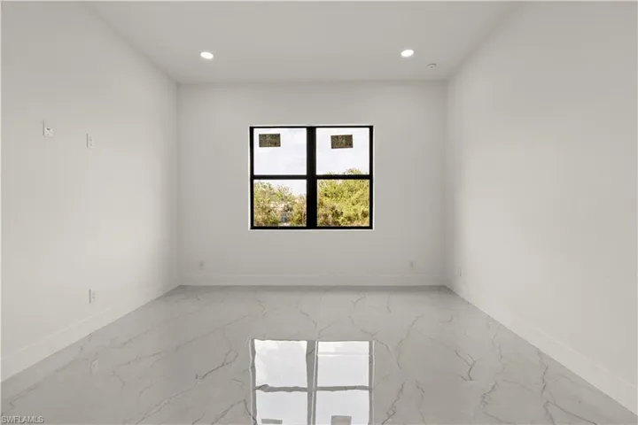 Unfurnished room with light marble finish floors, baseboards, and recessed lighting
