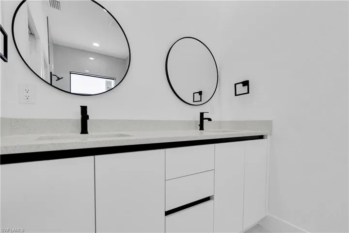 Bathroom featuring double vanity, recessed lighting, and baseboards
