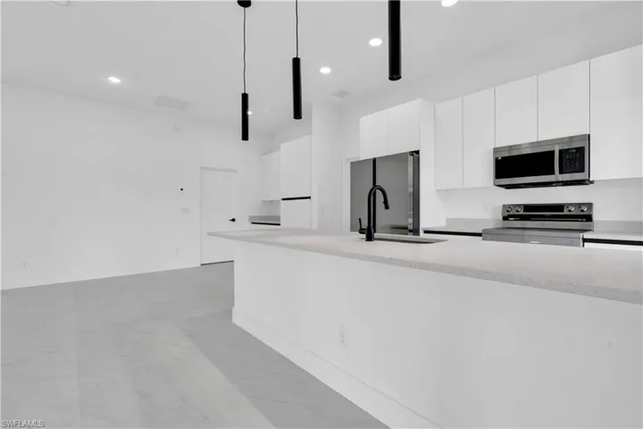 Kitchen featuring appliances with stainless steel finishes, a sink, white cabinetry, recessed lighting, and modern cabinets