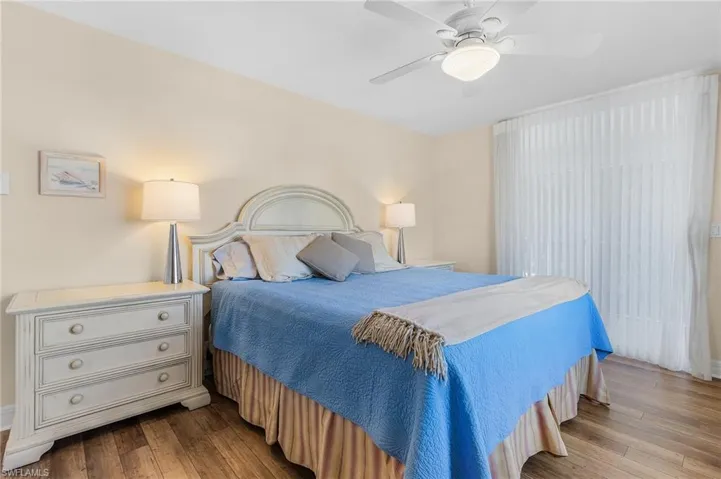 The spacious main bedroom features the easy-care wood-look flooring, ceiling fan and sliding doors out to the wrap-around lanai.