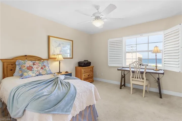 Enjoy working seated by this west facing window with views of the Gulf of Mexico in this cozy guest bedroom.