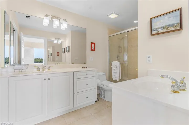 Bathroom featuring a shower with door, tile patterned floors, toilet, and vanity