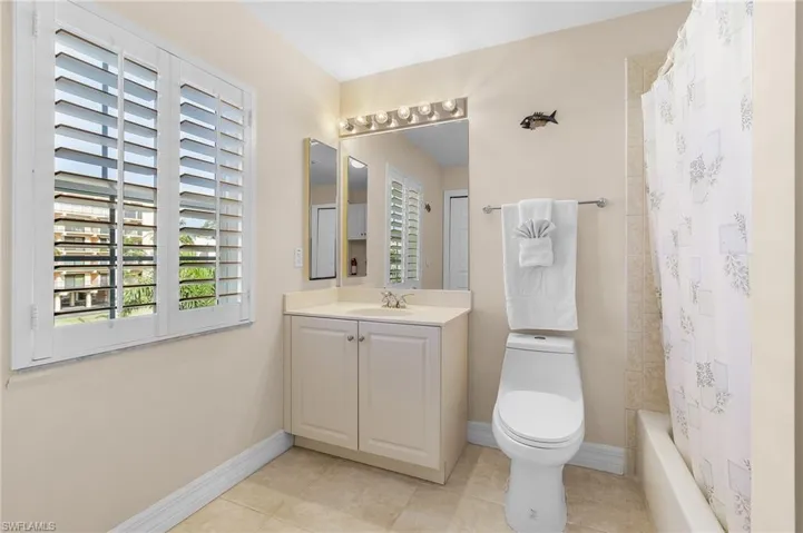 The upper level guest area features three bedrooms and two Full bathrooms.  This bathroom has a bathtub with shower head, and also includes a full size washer and dryer, and a laundry tub.