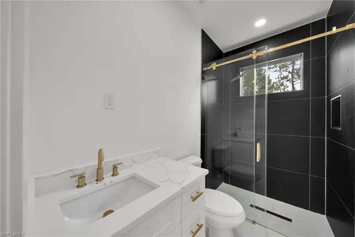 Full bath featuring a shower stall, vanity, and recessed lighting