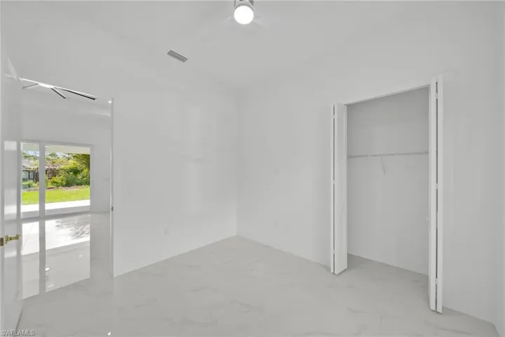 Unfurnished bedroom with marble finish floors, a closet, and ceiling fan