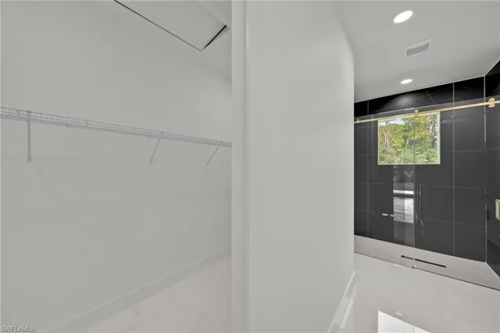 Walk in closet with marble tiled floors