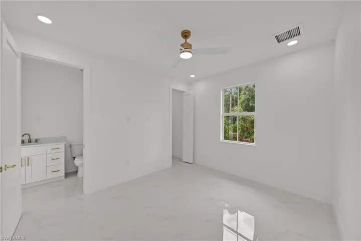Unfurnished bedroom with light marble finish floors, connected bathroom, recessed lighting, and ceiling fan