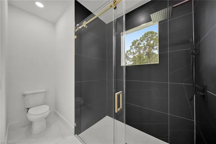 Full bathroom with a stall shower, marble look tile flooring, and recessed lighting