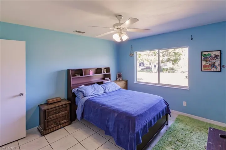 Bedroom with ceiling fan and light tile patterned flooring