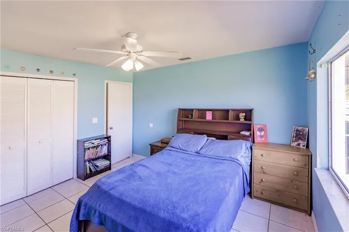Tiled bedroom with multiple windows, a closet, and ceiling fan