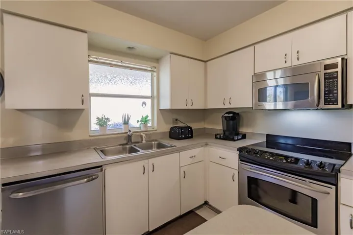 Kitchen featuring white cabinetry, sink, and appliances with stainless steel finishes