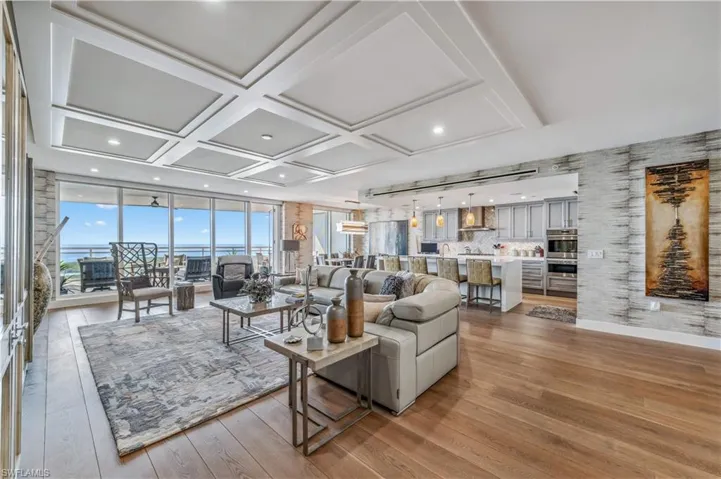 Living room with coffered ceiling and light wood-style floors