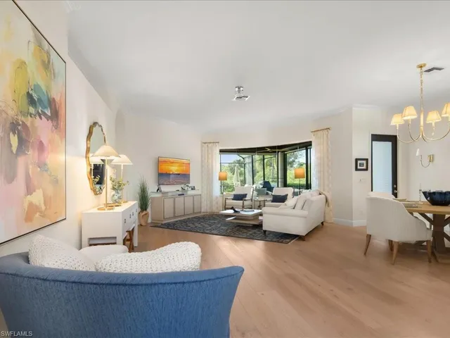 Living area with light wood-type flooring, crown molding, and hanging lights