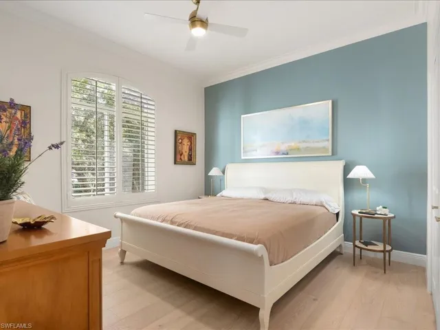 Bedroom featuring ornamental molding, light wood-style floors, and ceiling fan