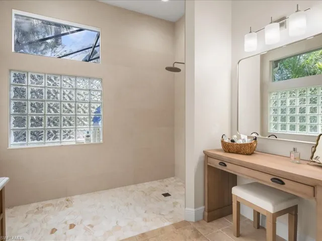 Bathroom featuring vanity, a walk in shower, and tile patterned flooring