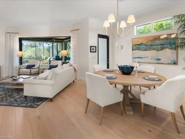 Dining space featuring light wood-style flooring, a chandelier, and crown molding