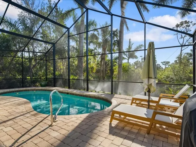 Swimming pool featuring a sunroom, a lanai, and a patio